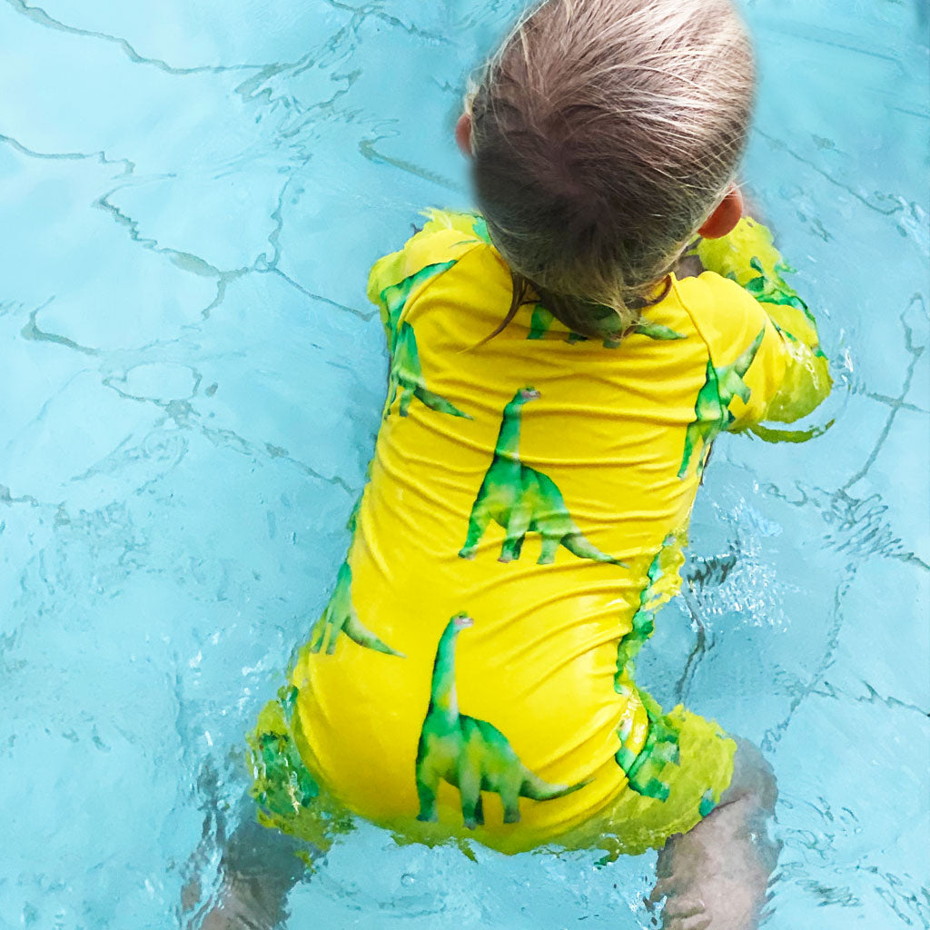 Boy in Pool Wearing Fluro Dinosaurs Unisex Long Sleeve Zip Swimmers