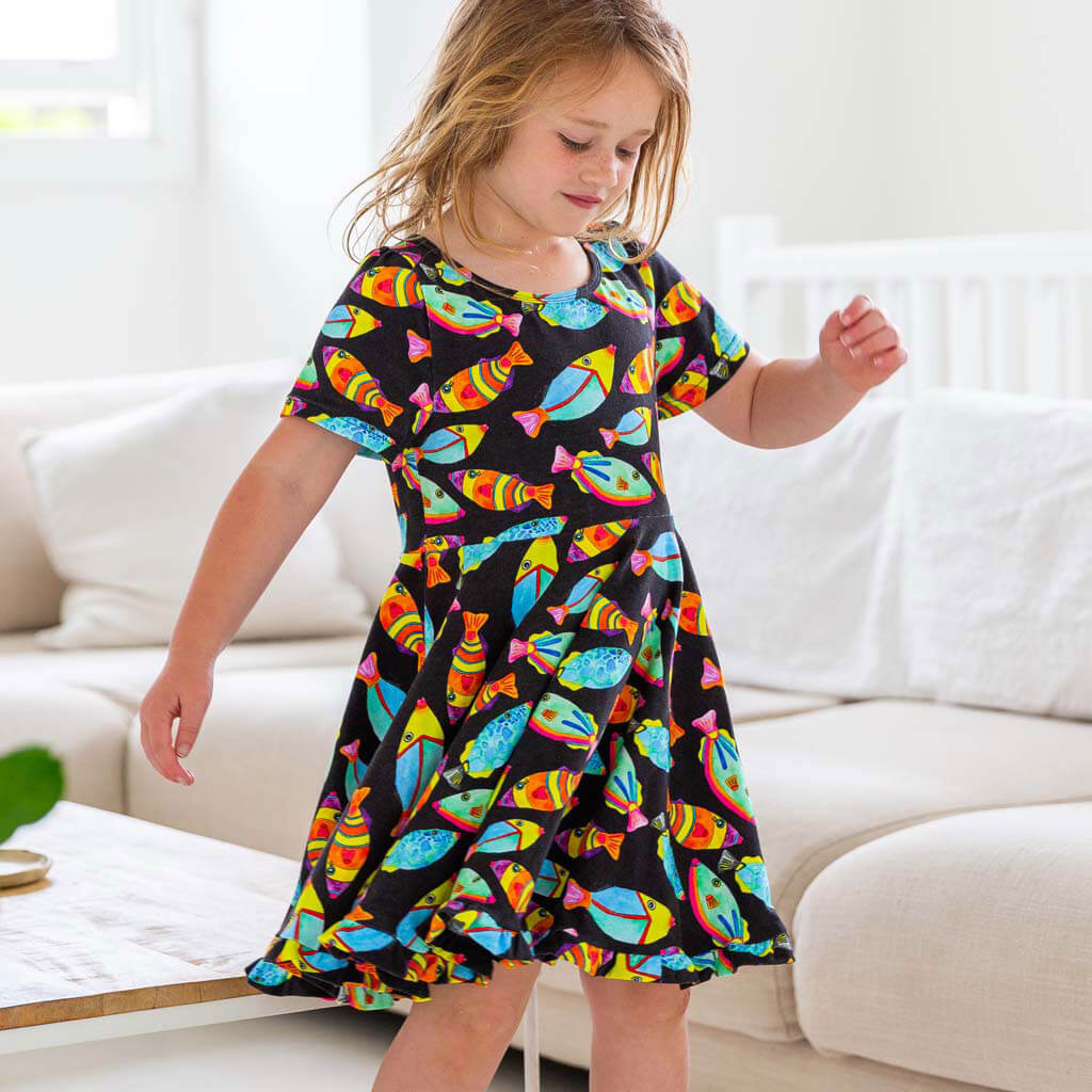 Girl Standing Wearing Neon Fish Short Sleeve Twirl Dress