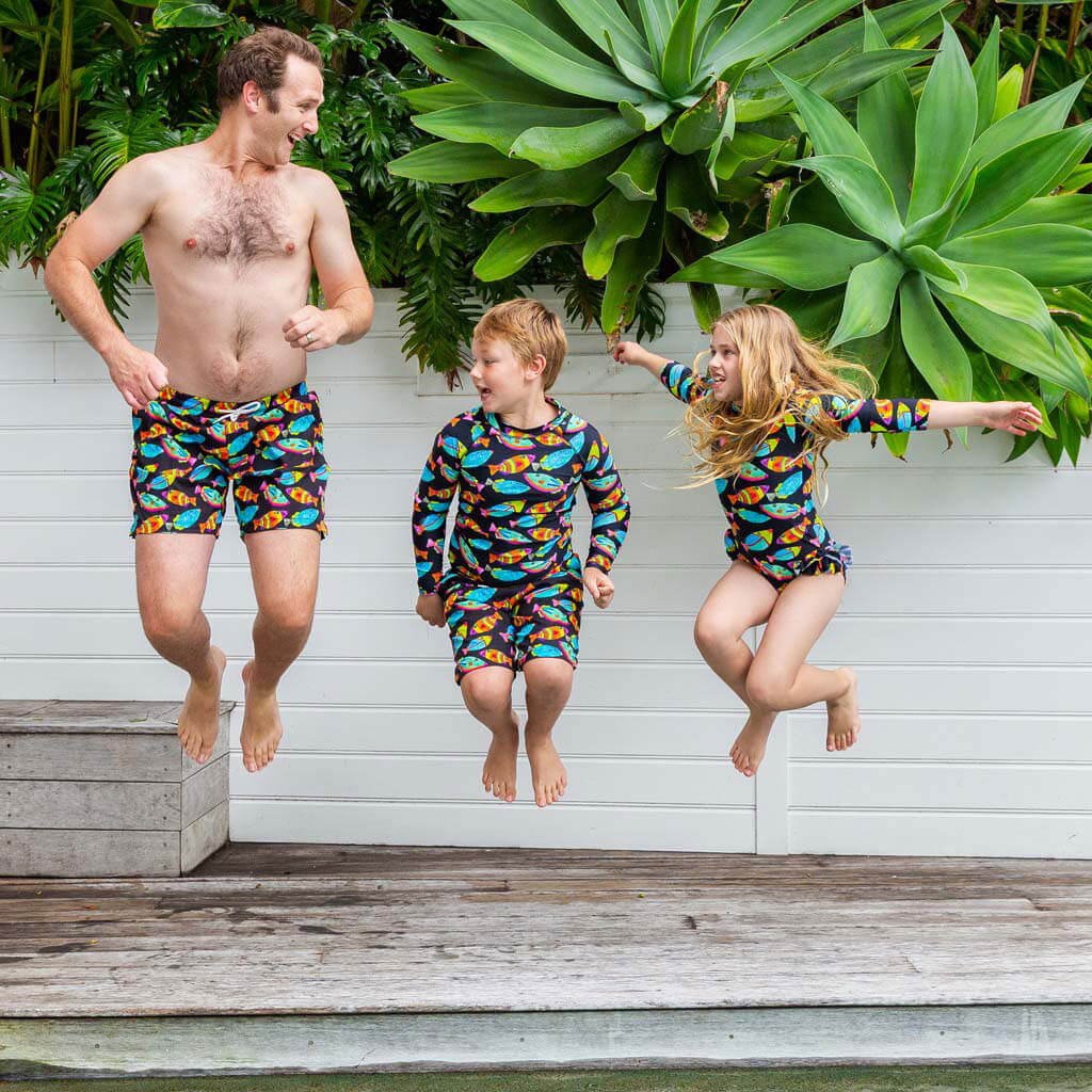 Man Jumping While Wearing Neon Fish Men's Boardshorts