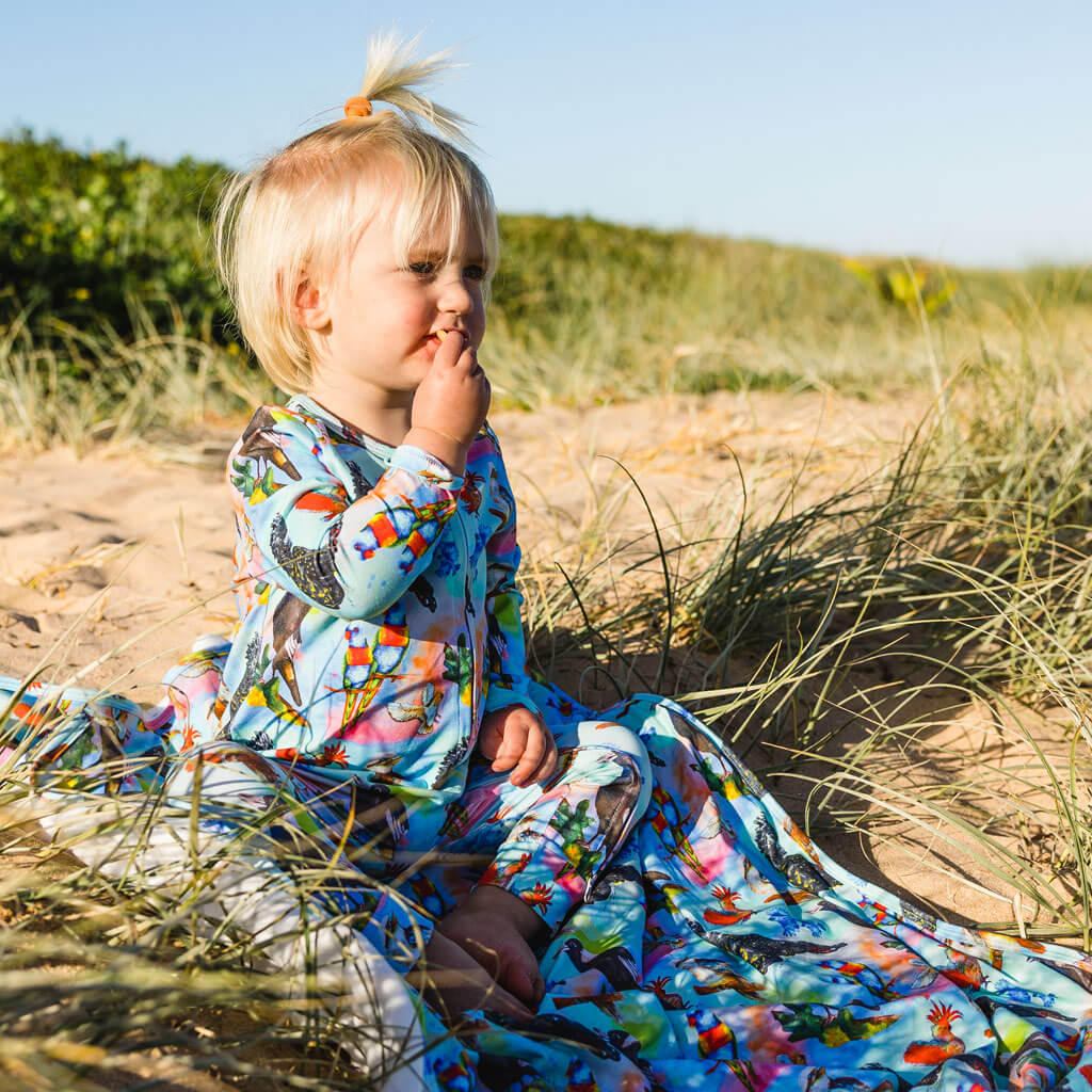 Little Boy Sitting Wearing Feathered Friends Long Sleeve Double Zip Sleepsuit