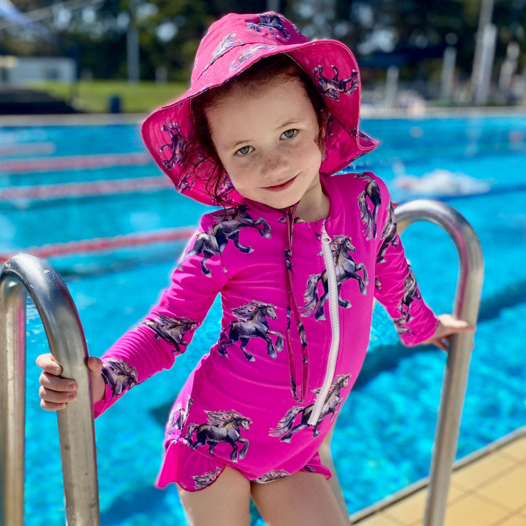 Girl at Pool Wearing Fluro Horses Girls Long Sleeve Zip Swimmers with Matching Hat
