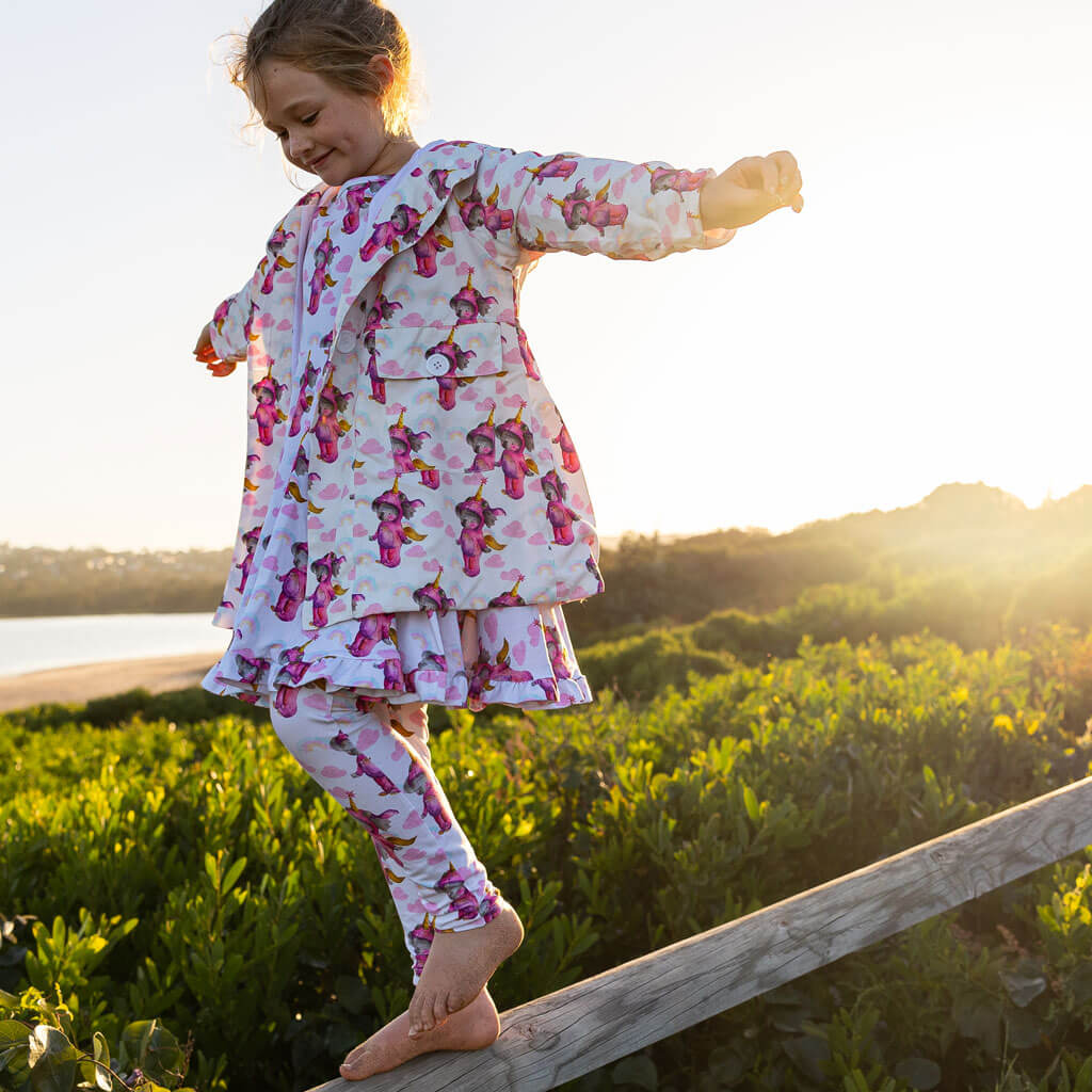 Girl Balancing On Fence Wearing Unicorn Koala Raincoat