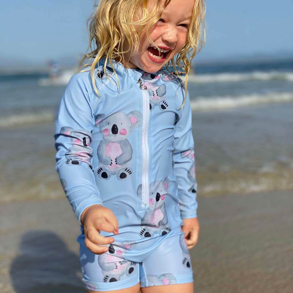 Girl At Beach Laughing While Wearing Blue Koala Unisex Zip Swimmers