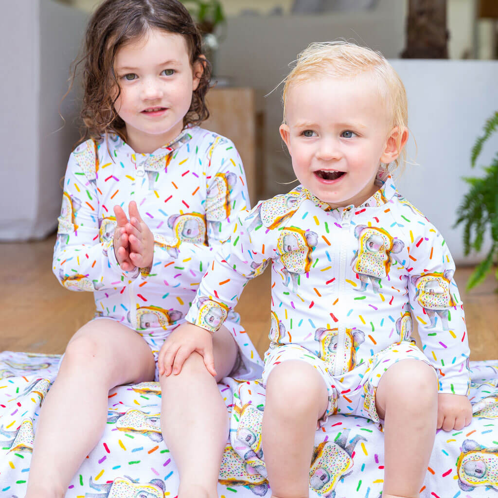 Girl Sitting While Wearing Fairy Bread Koala Girls Long Sleeve Zip Swimmers