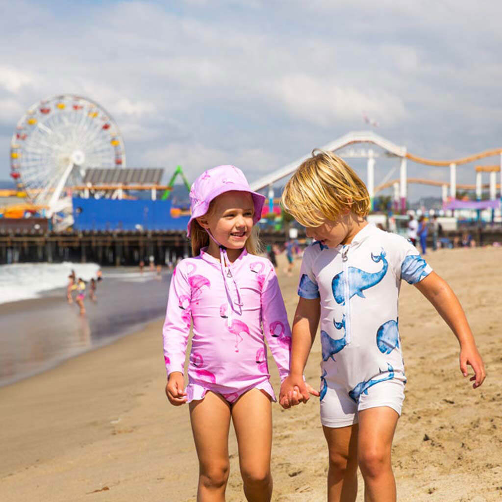 Girl On Beach With Boy While Wearing Flamingo Girls Long Sleeve Zip Swimmers