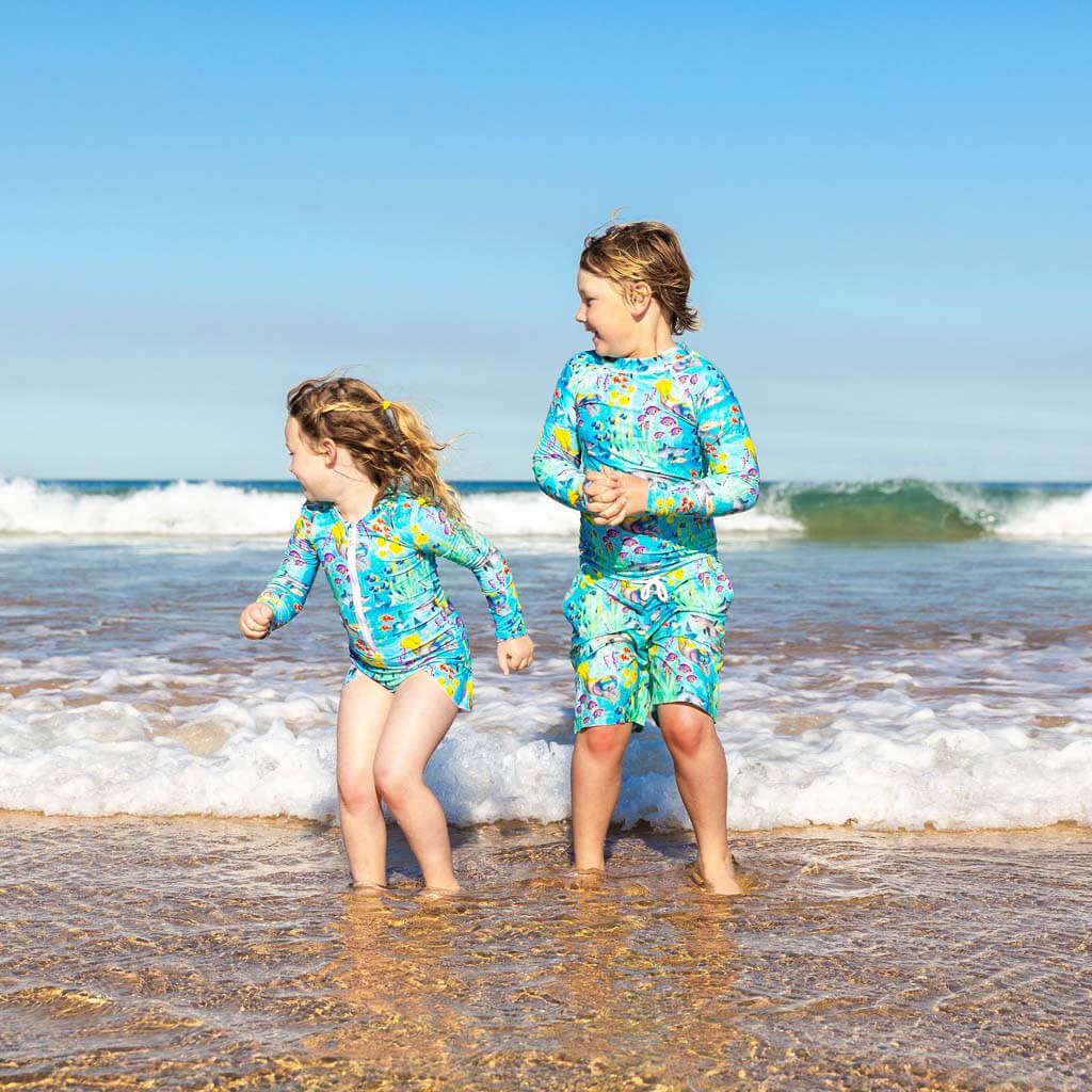 Boy At Beach Wearing Great Barrier Reef Kids' Boardshorts With His Sister