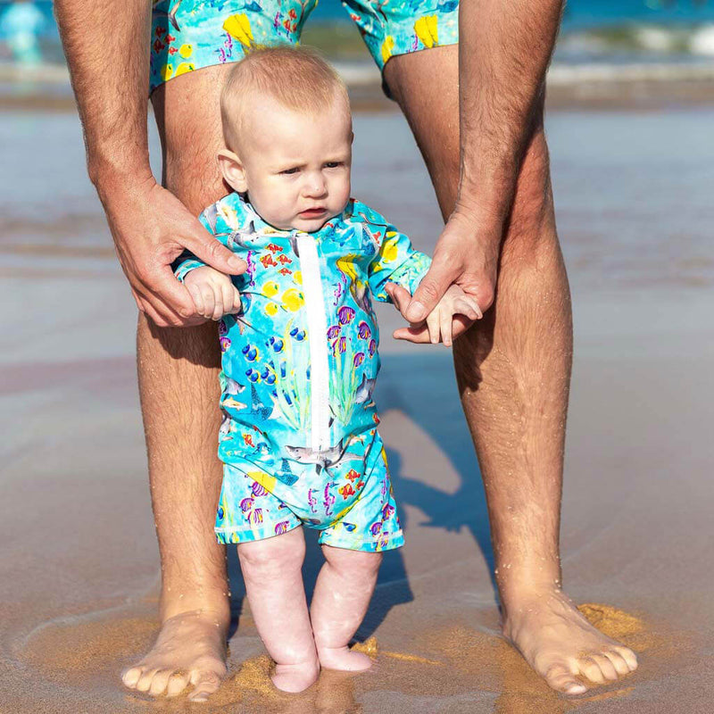 Baby Walking On Beach Being Supported by Dad Wearing Great Barrier Reef Unisex Long Sleeve Zip Swimmers