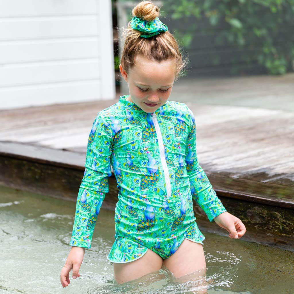 Girl Standing In Water Wearing Green Peacocks Girls Long Sleeve Zip Swimmers