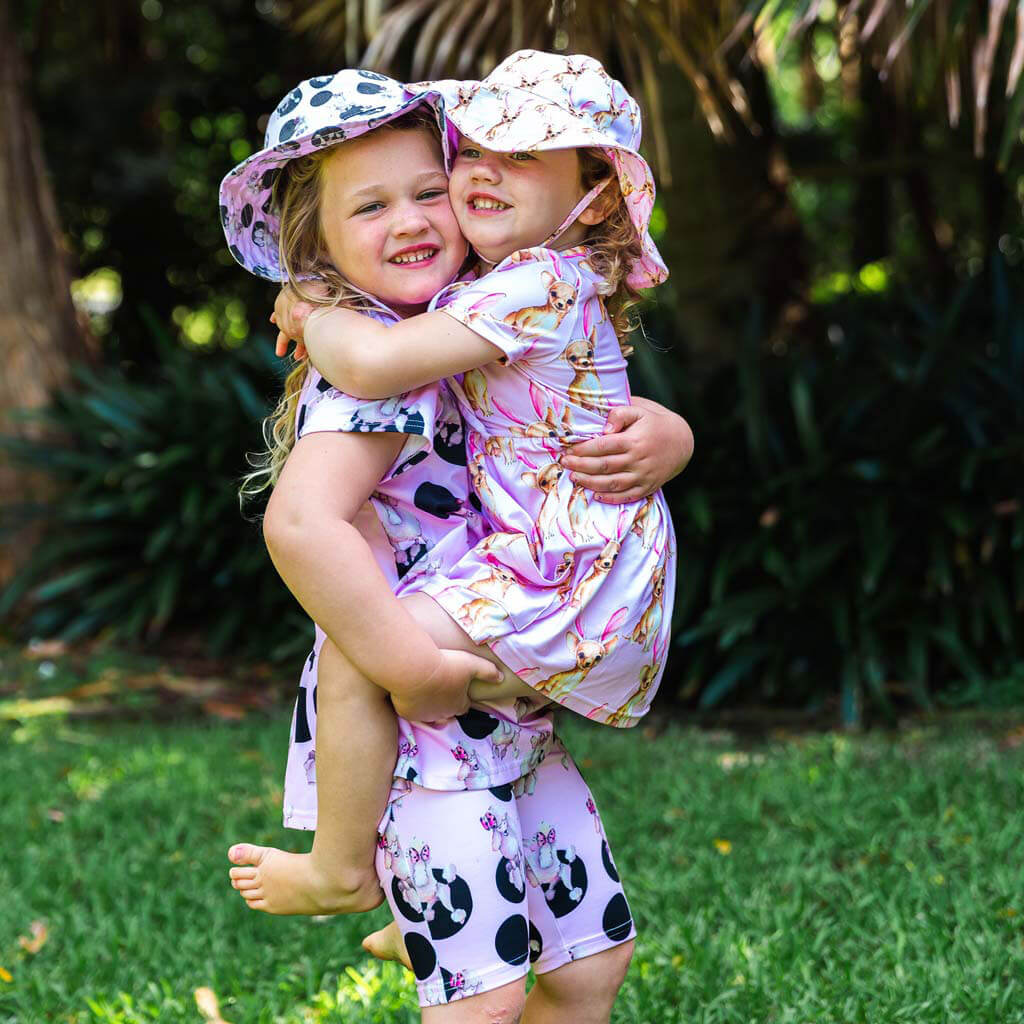 Girl Being Held By Big Sister While Wearing Chihuahua Bunny Beach Hat
