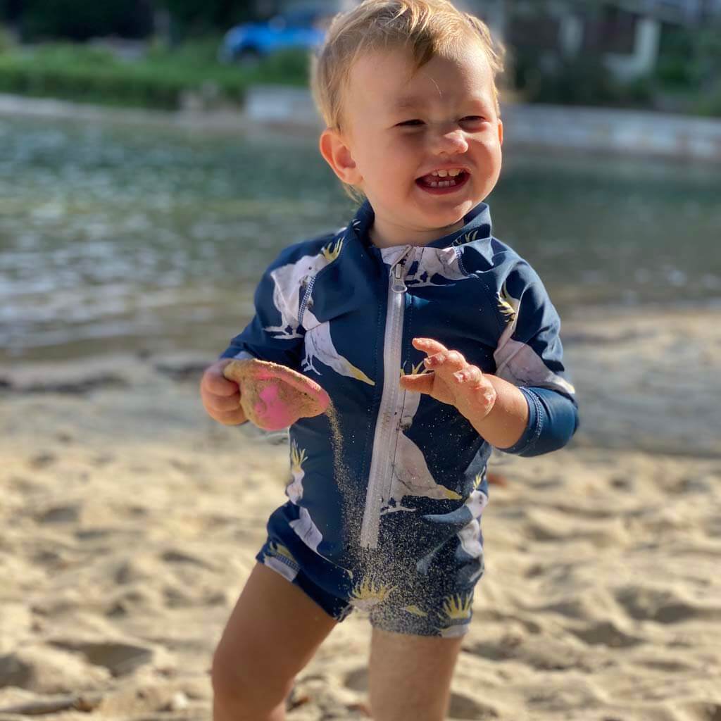 Toddler On Beach Wearing Navy Cockatoo Unisex Long Sleeve Zip Swimmers