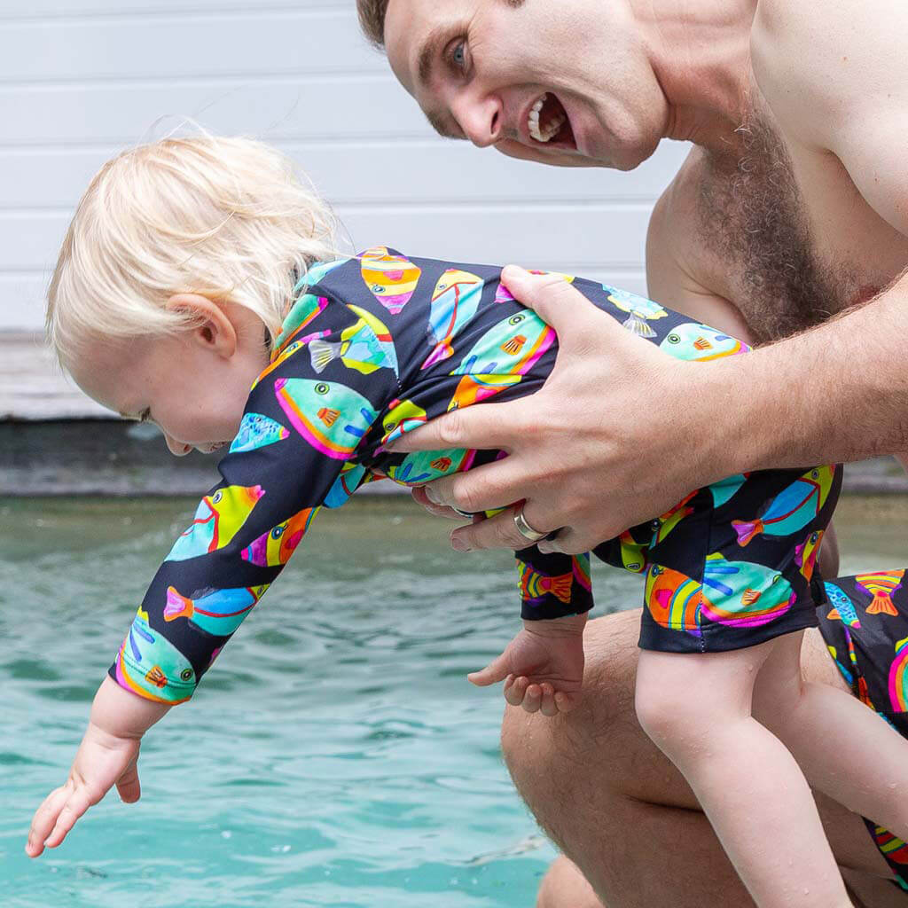 Toddler Smiling With Dad While Wearing Neon Fish Unisex Long Sleeve Zip Swimmers