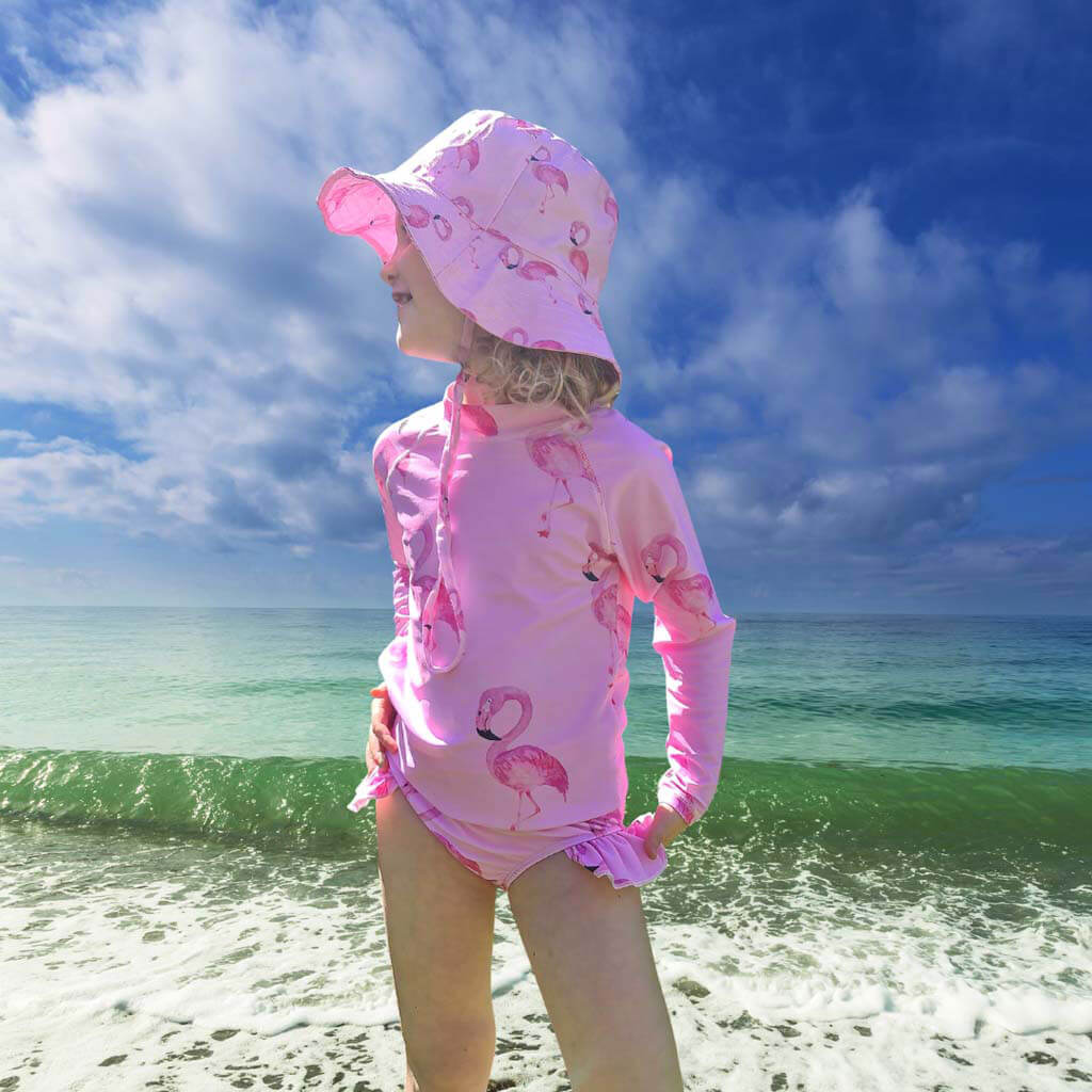 Girl On Beach With Waves Wearing Flamingo Frill Swim Bottoms